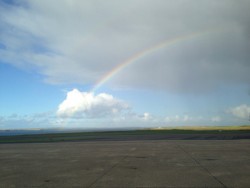 A rainbow disappearing into a cloud, over the runway at Kirkwall Airport, Orkney