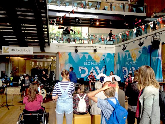 wide shot of Colston Hall foyer showing audence and musicians