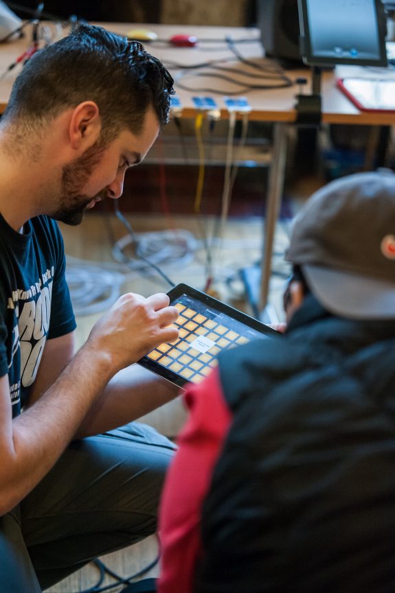 a music leader plays iPad with a young participant