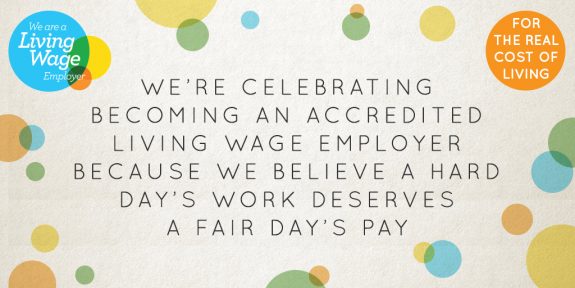 Living Wage banner reading we're celebrating becoming an accredited living wage employer because we believe a fair day's work deserves a fair fay's pay