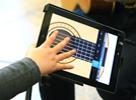 child's hand reaching out to play iPad instrument