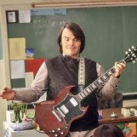 Man (Jack Black) with electric guitar strapped across his chest looking a bit silly
