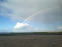 A rainbow disappearing into a cloud, over the runway at Kirkwall Airport, Orkney