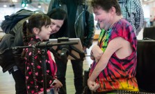A young girl smiles at a Disabled musician as he shows her something on an ipad