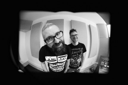 Black and white photo with distorted perspective of two male musicians