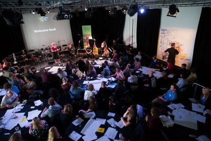 Image of circular tables at a training event in a large room