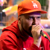 Brazilian rapper Billy Saga performing wearing a red baseball cap and red hoodie