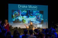 Daryl hosting the event in front of a large screen of projections