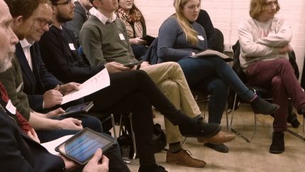 Photo: Participants playing iPads and listening to workshop presenter (out of frame)
