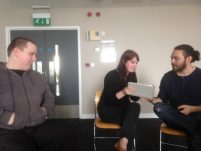 Two people look at a shared ipad