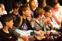 Young children in casual dress play instruments together