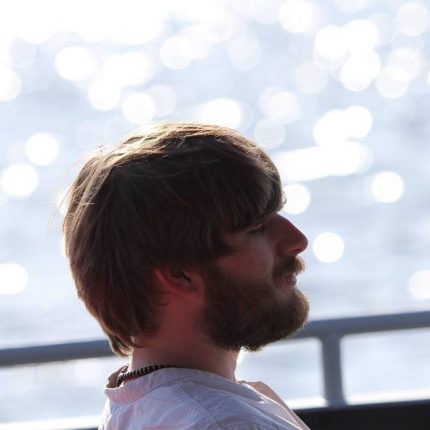 Ben is photographed in profile, in repose against a sparkling sea