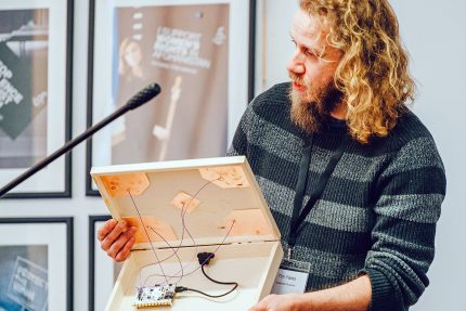 Tim holds open a wooden box with wires inside