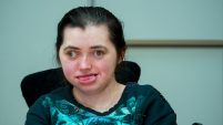 Lucy is a young white disabled woman with dark hair. Her