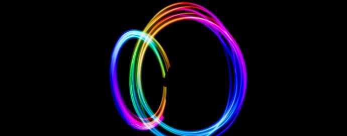Black background, two energetic swirls of light in rainbow colours
