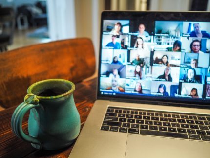 A mug and computer screen with zoom event visible