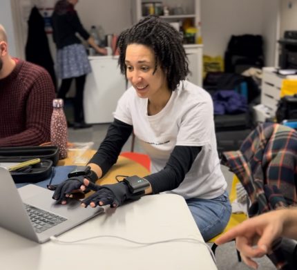 Photo of Ysabelle playing on mi mu gloves.