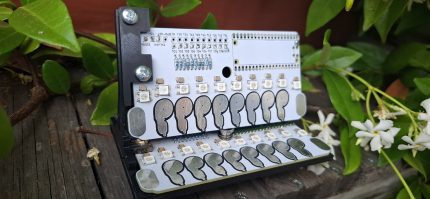 A piece of hardware that is used to control MIDI messaging. It has silver touchpads in the shape of finger prints and LED lights that are used to indicate when a sensor has been touched.