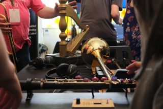 Two touch-based adapted instruments, the Touch Harp and Touch Trombone, placed next to each other on a black table cloth.