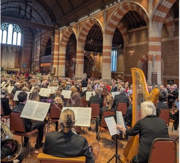 A large orchestra performing in a large cathedral or church building.