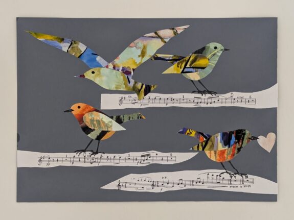 A collage made during Amelie's performance. It features 4 multi-coloured birds, perched on strips of sheet music and a heart.